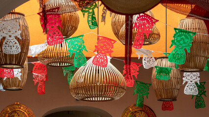 A bunch of paper lanterns hanging from the ceiling. The lanterns are decorated with different...