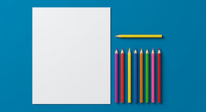 Colorful pencils and blank paper sheet with copy space on blue background, school stationery and creative art supplies.