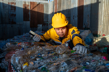 Waste Recycling Worker: A dedicated waste recycling worker is diligently sorting through a pile of recyclable plastics, emphasizing commitment to environmental preservation.