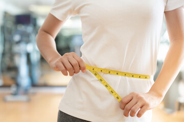 Diet and dieting. Beauty slim female body use tape measure on fitness. Woman in exercise clothes achieves weight loss goal for healthy life, crazy about thinness, thin waist, nutritionist.