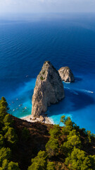 Aerial photo of Myzithres Zakynthos Greece showing steep cliffs turquoise cove sandy shoreline and dramatic rock formations in vivid blue sea
