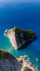 Aerial photo of Plakaki beach Zakynthos Greece showing limestone cliffs turquoise shallow waters deep blue ocean and rugged coastal scenery
