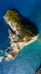 Plakaki island Zakynthos Greece aerial view with rocky cliffs green pine trees turquoise shallow waters and deep blue Ionian Sea surrounding coast