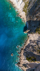 Overhead aerial view of Plakaki beach Zakynthos Greece with rocky peninsula turquoise coves deep blue Ionian Sea and rugged dry hills above coast