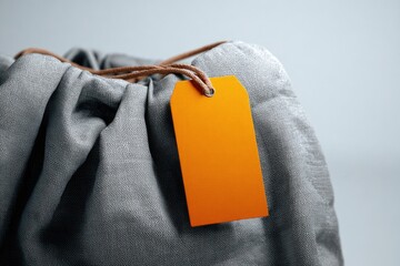 Gray cloth drawstring bag with orange tag