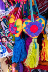 A colorful collection of knitted items, including a heart-shaped ornament and a flower-shaped...