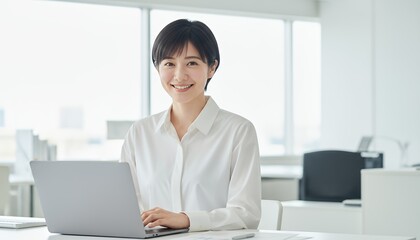 白を基調としたオフィスで働く笑顔の女性