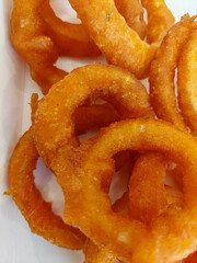 Close-up of golden brown crispy onion rings, deep-fried snack with crunchy texture. Tasty fast food appetizer, delicious fried snack served hot and fresh