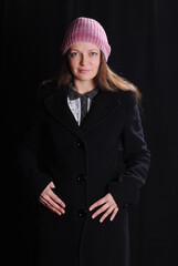 girl in a sweater and hat on a black background