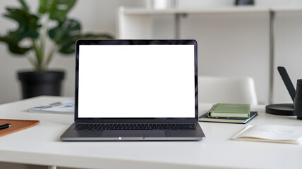 Open modern laptop displaying blank screen on a clean white desk with office accessories and a plant, perfect for creative projects and business presentations.