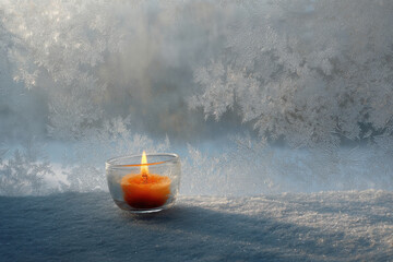 frostcovered window adorned with intricate icy patterns presents solitary flicker of candle warm glow