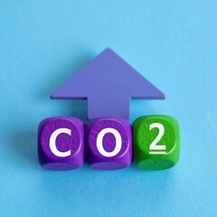 Rising CO2 Levels: Colorful Wooden Blocks and Upward Arrow on Blue Background