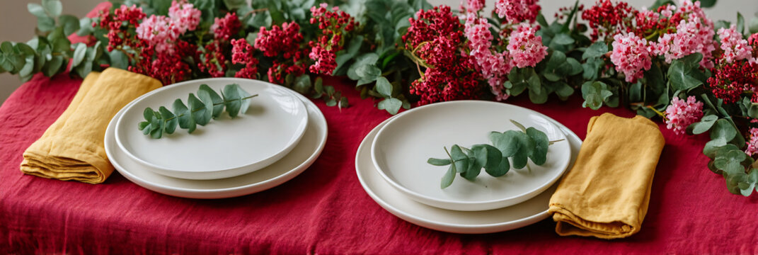 Elegant holiday table setting with eucalyptus runner and red napkins, wide bottom copy space for menu