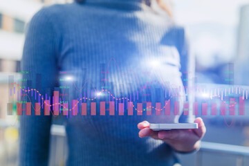 Modern businesswoman with smartphone in hands, global trading graphs and map backdrop.