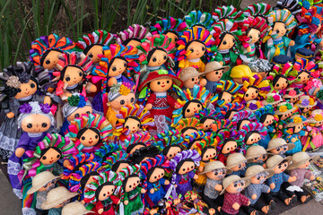 A diverse collection of colorful dolls, each with unique outfits and accessories, are displayed in...