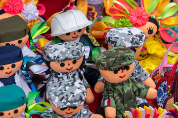 Naklejka premium A group of stuffed soldiers are sitting on a table. The soldiers are wearing camouflage. Historic center of Queretaro City, decorations and traditions to celebrate Mexico's Independence Day, colonial 