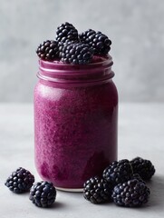 Vibrant blackberry smoothie in a mason jar garnished with fresh blackberries, ideal for health and wellness visuals.