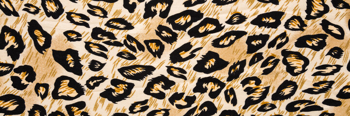 Dark black yellow soft leopard spot pattern fabric background. Wide banner. Closeup. Top down view.