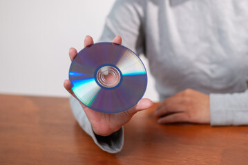 User holding cd indoor setting technology content minimalist environment close-up view digital media concept