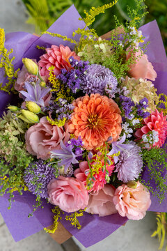 Summer bouquet. Beautiful purple, blush and orange fresh flower arrangement. Birthday or weddding bouquet made of summer flowers.