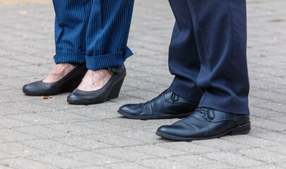 Obraz na płótnie Canvas Two people standing next to each other with their feet on the ground