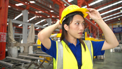 Young woman experienced technician checking large machine on a production line