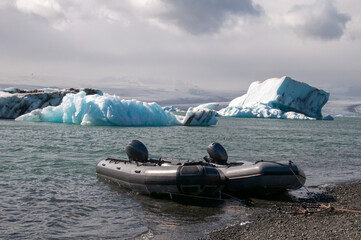 Jokulsarlon Iceland, zodiac moored near shore with icebergs and glacier in background
