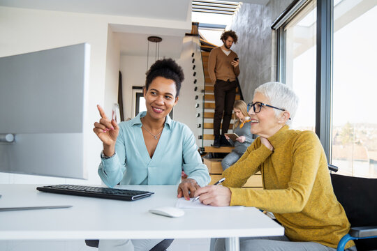 Diverse group of businesspeople discussing charts during a meeting together in a modern office