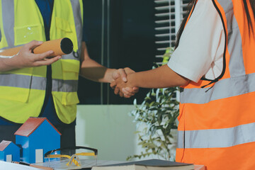 Closeup of team of industrial engineers meeting analyze machinery blueprints consult project on table in manufacturing factory. Working in manufacturing plant or production plant.