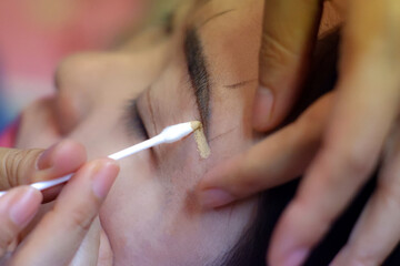 Using concealer to cover eyebrows.