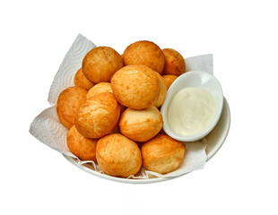 Golden baursaks on a paper towel with kaymak in a white bowl — a cozy presentation of a...