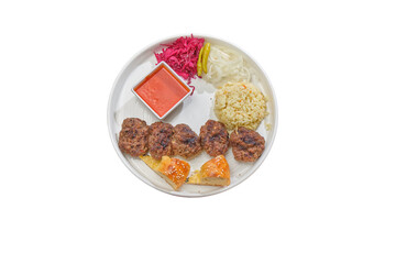 Grilled beef patties with microgreens, mashed potatoes, chips, sauce, and fresh vegetables — a balanced dish on a white plate.