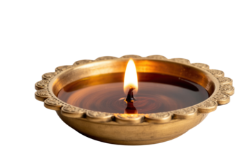 A lit oil lamp in an ornate brass bowl, casting a warm glow. background removed