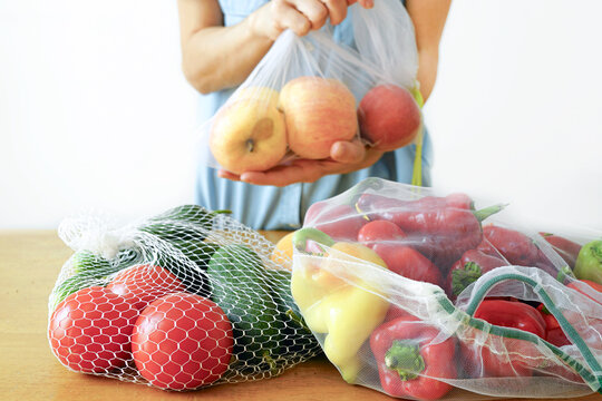 Person demonstrating healthy meal prep with organic apples and rainbow vegetables for balanced diet. Fresh seasonal produce selection for wellness lifestyle and clean eating habits. Natural nutrition.