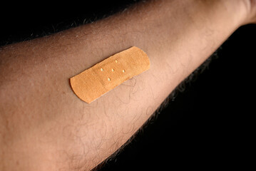 Close-Up of Bandage on an Arm with Dark Background