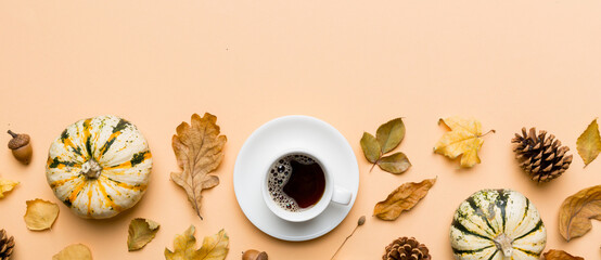 Flat lay composition with colorful Autumn cup of coffee and leaves on a color background. top view