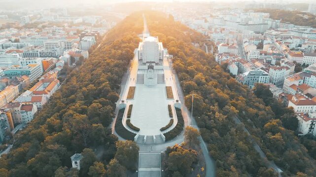 Witness the stunning sunrise illuminating the National Monument at Vitkov Hill. This iconic memorial dedicated to Jan Zizka showcases beautiful city views and lush surroundings.