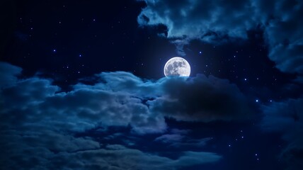 Mysterious full moon shines through dramatic dark blue clouds against a starry night sky