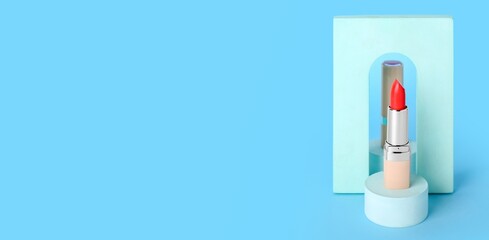 Decorative podiums with lipstick on light blue background with space for text