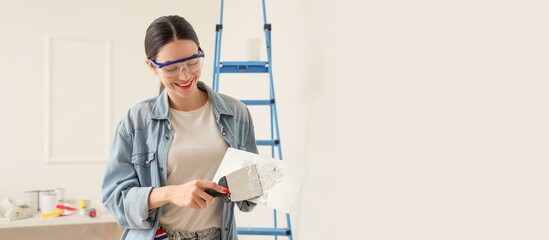 Young woman with putty knives in room. Banner for design