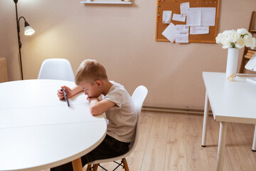 A boy with hearing aids engages with a smartphone, playing mobile games with focused enjoyment....