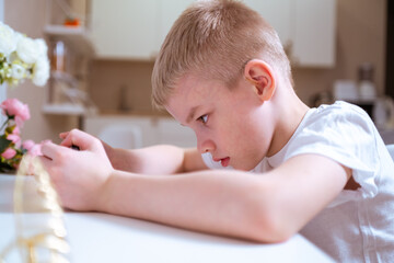 A boy with hearing aids engages with a smartphone, playing mobile games with focused enjoyment....