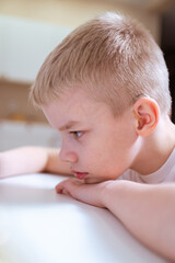 A boy with hearing aids engages with a smartphone, playing mobile games with focused enjoyment. Captures modern childhood, adaptive technology, and inclusive digital play