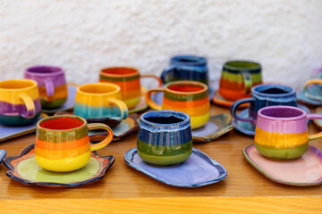 colorful ceramic cups on wooden table retale outdoors