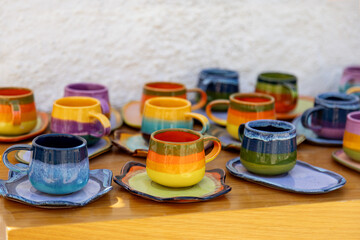 colorful ceramic cups on wooden table retale outdoors