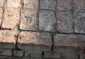 Old weathered red brick pavement with rough textured surface