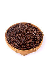 Roasted coffee beans in a small woven basket on white.