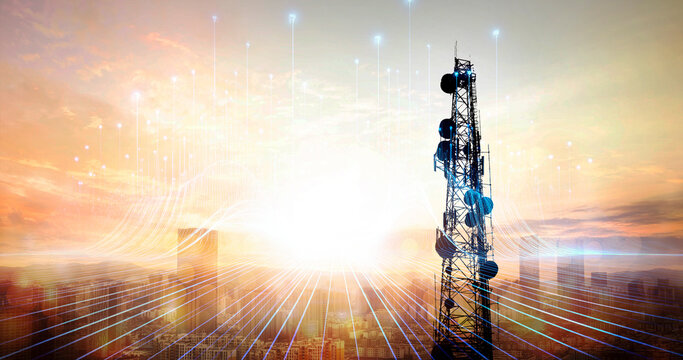 Telecommunication tower against sunset over cityscape. 