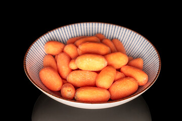 Peeled mini carrots isolated on black background, macro.