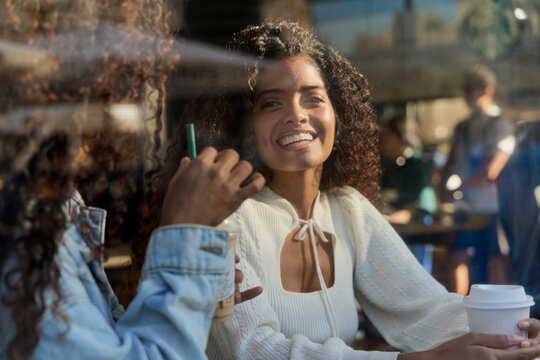 Happy young women enjoying coffee and conversation